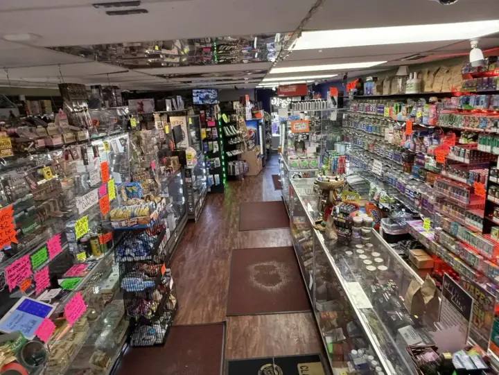 Long aisle of stocked shelves and glass counters inside Smoker's Alley, 27738 Gratiot Ave, Roseville