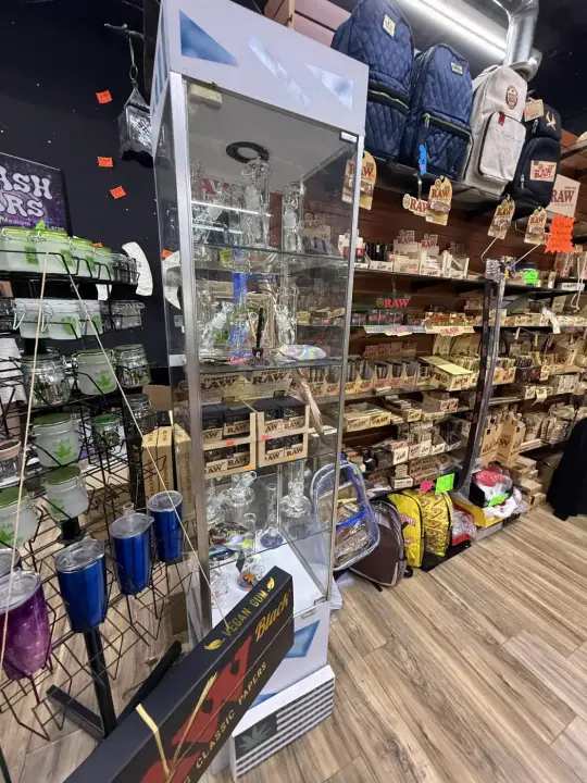 Tall glass display cases beside wooden shelves at Smoker's Alley Gallery, 13 Mile Rd, Roseville