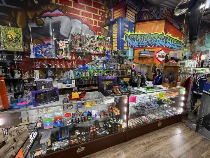 Glass counter in front of the glass wall and the street-art mural at Smoker's Alley Gallery in Roseville