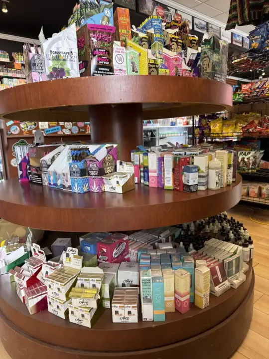 Round wooden display table stocked with products at Smokers Alley Headquarters, Roseville, MI